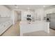 Bright, all-white kitchen featuring a large quartz island, stainless steel appliances, and tile flooring at 3603 Night Star Terrace, Parrish, FL 34219