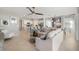 Spacious living room featuring tile floors, large sofa, ceiling fan, and an open concept layout to the modern kitchen at 3603 Night Star Terrace, Parrish, FL 34219