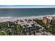 Aerial view of a community featuring beach access with picnic tables, palms, and nearby building at 3617 Fair Oaks Pl, Longboat Key, FL 34228