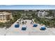 Community aerial view of a beach with blue picnic tables and manicured lawns, buildings and palm trees at 3617 Fair Oaks Pl, Longboat Key, FL 34228