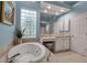 Bathroom features a soaking tub with tile surround, vanity, and glass block window at 3617 Fair Oaks Pl, Longboat Key, FL 34228