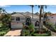 Charming home featuring tropical landscaping, a tile roof, and an attached two-car garage at 3617 Fair Oaks Pl, Longboat Key, FL 34228