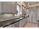 Stylish kitchen with gray cabinets, stainless steel appliances, and sleek granite countertops at 3617 Fair Oaks Pl, Longboat Key, FL 34228