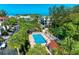Aerial view showcasing a refreshing community pool surrounded by lush landscaping and amenities at 3805 E Bay Dr # 301, Holmes Beach, FL 34217