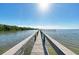 Long wooden pier stretches out over calm, clear water on a sunny day with bright blue skies at 3805 E Bay Dr # 301, Holmes Beach, FL 34217