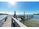 Wooden pier featuring seating area, umbrella, and dock for relaxation and scenic waterfront views at 3805 E Bay Dr # 301, Holmes Beach, FL 34217