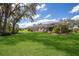 Manicured backyard with lush green grass and tropical foliage, creating a private oasis for relaxation and outdoor enjoyment at 3902 162Nd E Ave, Parrish, FL 34219