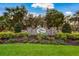 Inviting entrance to Twin Rivers with stone signage, manicured landscaping, and lush green lawn, setting a welcoming tone at 3902 162Nd E Ave, Parrish, FL 34219