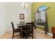 Cozy dining area with a dark wood table set under a chandelier, lit by a window with patterned curtains at 3902 162Nd E Ave, Parrish, FL 34219