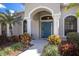 Charming home entrance featuring a blue front door, stone columns, arched window, and manicured garden at 3902 162Nd E Ave, Parrish, FL 34219