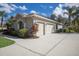Side view of a home featuring a spacious three-car garage with a wide driveway and manicured landscaping at 3902 162Nd E Ave, Parrish, FL 34219