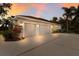 A well-lit three car garage with a neutral color palette, ample parking space and manicured landscaping at 3902 162Nd E Ave, Parrish, FL 34219