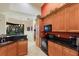 Kitchen featuring granite countertops and wood cabinetry, adjacent to a tall accent wall at 3902 162Nd E Ave, Parrish, FL 34219