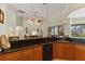 Open-concept kitchen with dark countertops and warm wood cabinets, flowing into adjacent living spaces at 3902 162Nd E Ave, Parrish, FL 34219
