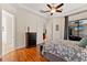 Comfortable bedroom featuring a tray ceiling, wood floors, and access to en suite bathroom at 3902 162Nd E Ave, Parrish, FL 34219