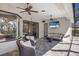 Relaxing covered patio features comfortable seating, a ceiling fan, and a mounted television for outdoor entertainment at 3902 162Nd E Ave, Parrish, FL 34219