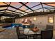 A screened-in patio area with a table for four overlooking the pool and backyard at 3902 162Nd E Ave, Parrish, FL 34219