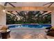 A covered pool is surrounded by brick patio and lounge furniture perfect for relaxation at 3902 162Nd E Ave, Parrish, FL 34219