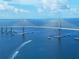 Scenic aerial view showcasing a striking suspension bridge over the water with boats sailing below at 4460 Ironwood Cir # 505Ad, Bradenton, FL 34209