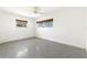 Clean bedroom featuring two windows, a ceiling fan, neutral walls and concrete flooring at 45 Cape Haze Dr, Placida, FL 33946