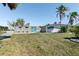 Charming single-story home featuring a well-manicured lawn, mature landscaping, and a vibrant blue front door at 45 Cape Haze Dr, Placida, FL 33946
