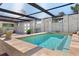 Inviting in-ground pool area featuring a translucent roof, tile surround, with lounge seating and mature landscaping at 45 Cape Haze Dr, Placida, FL 33946