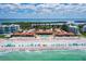 Gorgeous aerial view of beachside condos with a private beach, turquoise ocean, and blue umbrellas at 4621 Gulf Of Mexico Dr # 19B, Longboat Key, FL 34228