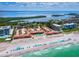Gorgeous aerial view of beachfront condos with private pool and beach access, complete with blue umbrellas on white sand at 4621 Gulf Of Mexico Dr # 19B, Longboat Key, FL 34228