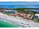 Beautiful aerial view of beachfront condos with private pool and beach access with blue umbrellas on white sand at 4621 Gulf Of Mexico Dr # 19B, Longboat Key, FL 34228