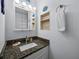 Bathroom vanity with granite countertop, built-in shelving, and decorative marine details at 4621 Gulf Of Mexico Dr # 19B, Longboat Key, FL 34228
