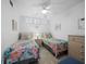 Cozy bedroom featuring twin beds with floral bedding, ceiling fan, and bright natural light at 4621 Gulf Of Mexico Dr # 19B, Longboat Key, FL 34228