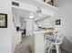 Galley kitchen with white cabinetry and a breakfast bar, offering a cozy and functional space at 4621 Gulf Of Mexico Dr # 19B, Longboat Key, FL 34228