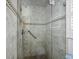 Walk-in shower featuring neutral tile, glass door, grab bar and handheld shower head at 4621 Gulf Of Mexico Dr # 19B, Longboat Key, FL 34228