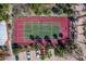 Overhead view of a tennis court with red and green surfaces, complete with basketball hoop and parking area at 4621 Gulf Of Mexico Dr # 19B, Longboat Key, FL 34228