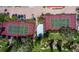 Aerial view of two well-maintained tennis courts with surrounding landscaping and parking area at 4621 Gulf Of Mexico Dr # 19B, Longboat Key, FL 34228