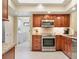 Well-lit kitchen features wood cabinetry, stainless steel appliances, and granite countertops at 4770 Maid Marian Ln, Sarasota, FL 34232