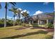 Beautiful backyard featuring a screened-in lanai surrounded by swaying palm trees and well-manicured landscaping at 5007 Palermo Dr, Punta Gorda, FL 33950