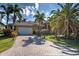 Long brick driveway leads up to the house, beautiful green lawn and many palm trees at 5007 Palermo Dr, Punta Gorda, FL 33950