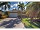 Beautiful single-story home featuring a tile roof, two-car garage and lush landscaping including palm trees at 5007 Palermo Dr, Punta Gorda, FL 33950