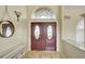Inviting foyer showcasing double front doors, transom window, travertine flooring, and neutral wall color at 5007 Palermo Dr, Punta Gorda, FL 33950