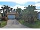 Charming home with a brick driveway, two car garage, and tropical landscaping at 5007 Palermo Dr, Punta Gorda, FL 33950