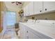 Laundry room with washer, dryer, white cabinets and tile floor at 5007 Palermo Dr, Punta Gorda, FL 33950