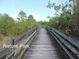 Picturesque nature park boardwalk surrounded by lush greenery and trees under a clear blue sky at 5007 Palermo Dr, Punta Gorda, FL 33950