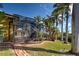 Enclosed pool with brick-paved path, lush tropical greenery, and a screened-in lanai for outdoor relaxation at 5007 Palermo Dr, Punta Gorda, FL 33950