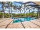 Sparkling screened-in pool with lush landscaping and a clear blue sky at 5007 Palermo Dr, Punta Gorda, FL 33950