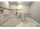 Luxurious walk-in shower with neutral stone-look tiles and a shower bench at 5007 Palermo Dr, Punta Gorda, FL 33950