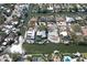 Aerial view of waterfront property with private dock, lush landscaping, and sparkling pool, situated on a canal with easy access to the bay at 5169 Sandy Shore Ave, Sarasota, FL 34242