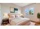 Elegant bedroom features a plush bed, stylish nightstands with lamps, and a window with a view of palm trees at 5169 Sandy Shore Ave, Sarasota, FL 34242