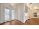 Bright entryway with glass paneled double doors, hardwood flooring, and built in cabinets and drawers at 5169 Sandy Shore Ave, Sarasota, FL 34242