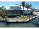 Aerial view of a waterfront home with a private dock, lift, and screen-enclosed pool at 5169 Sandy Shore Ave, Sarasota, FL 34242